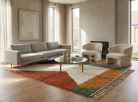 A large, custom-made Beni Ourain area rug anchored in a bohemian living room setting, placed beneath a velvet sofa and reclaimed wood coffee table, highlighting its warm earth tone palette.