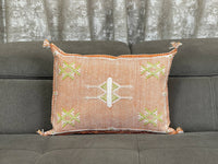 orange Handwoven Moroccan pillow with white Berber patterns