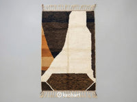 Custom Beni Ourain Moroccan wool rug flat lay showing plush cream pile with toffee, camel, and Sahara brown geometric diamond patterns and traditional fringe.